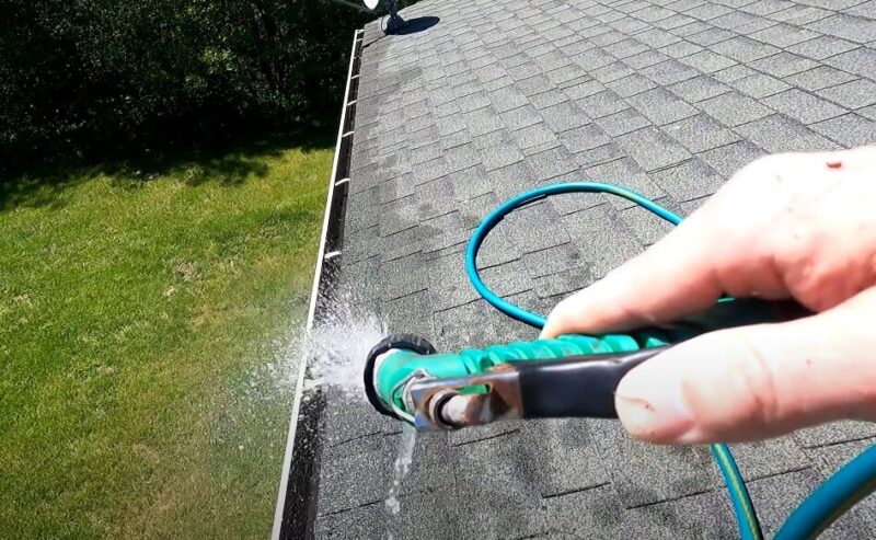 High-pressure water jet cleans roof gutters