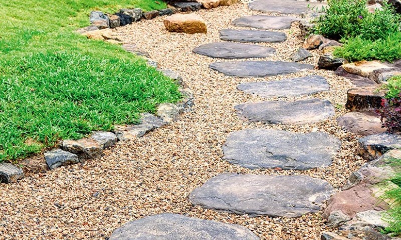 Garden path with large, flat stepping stones arranged on gravel
