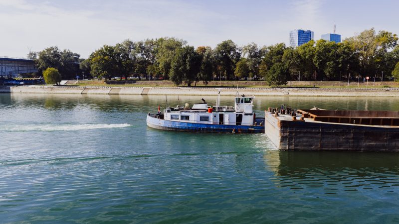 Cargo ship navigating the Danube River under a clear sky, illustrating inland barge logistics