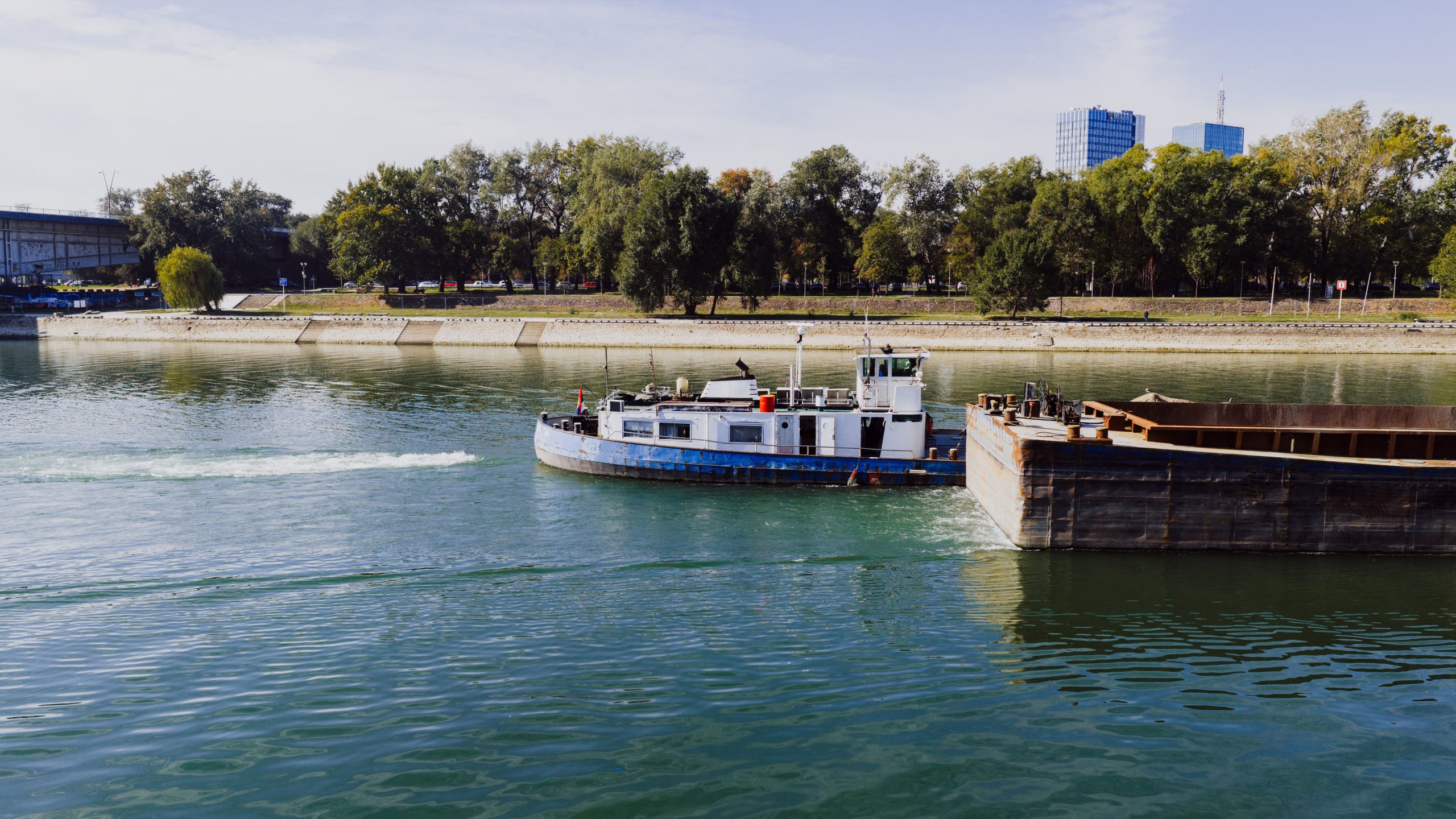 Cargo ship navigating the Danube River under a clear sky, illustrating inland barge logistics