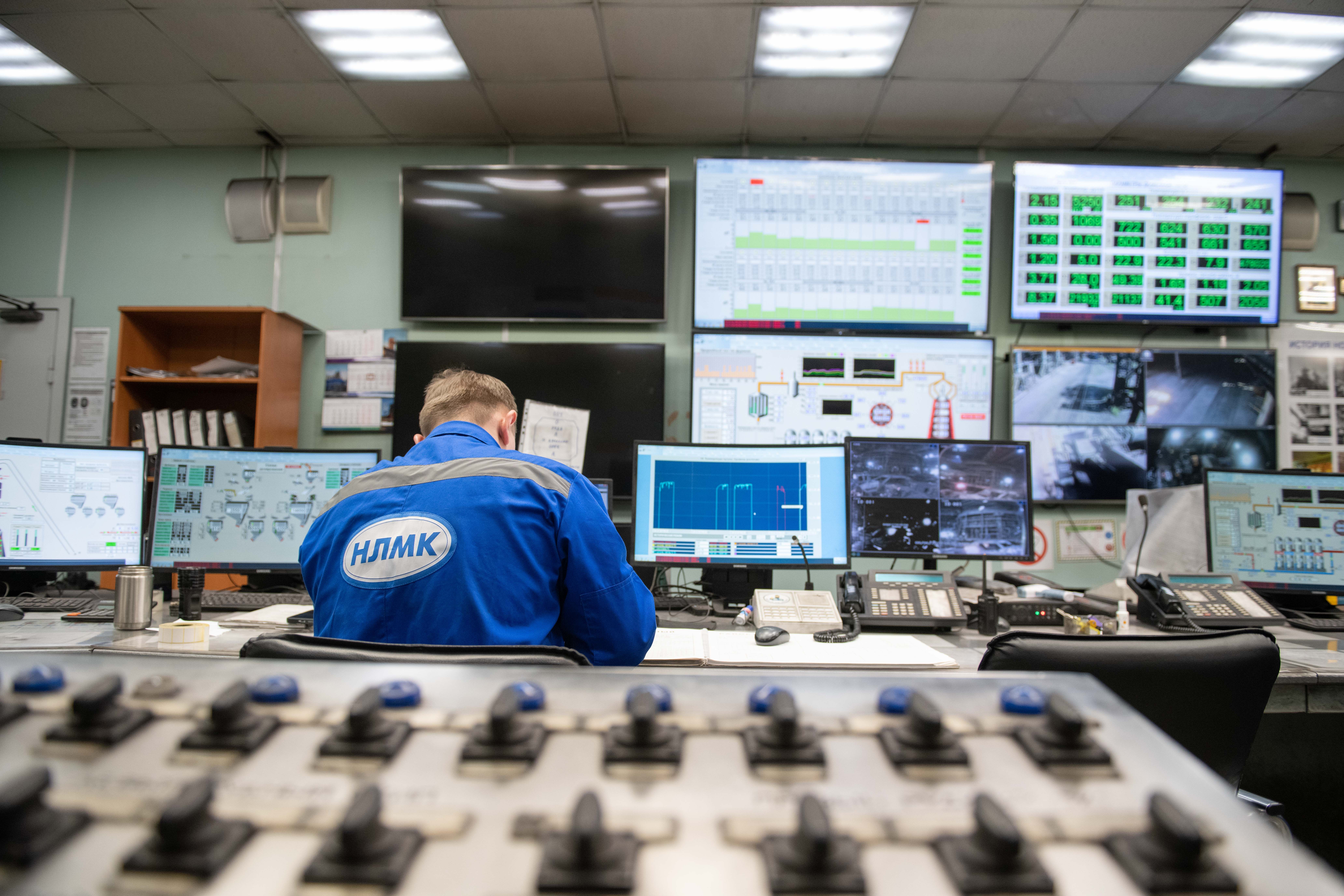 Engineer monitoring multiple screens in an industrial control room powered by digital twin data